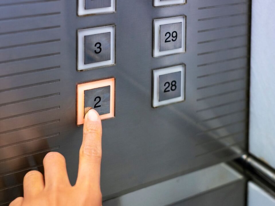 Persona tocando el botón del ascensor